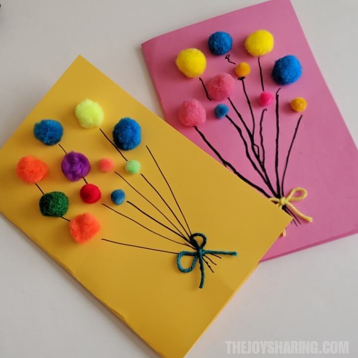 yellow card and pink card with small colorful pompoms glued on