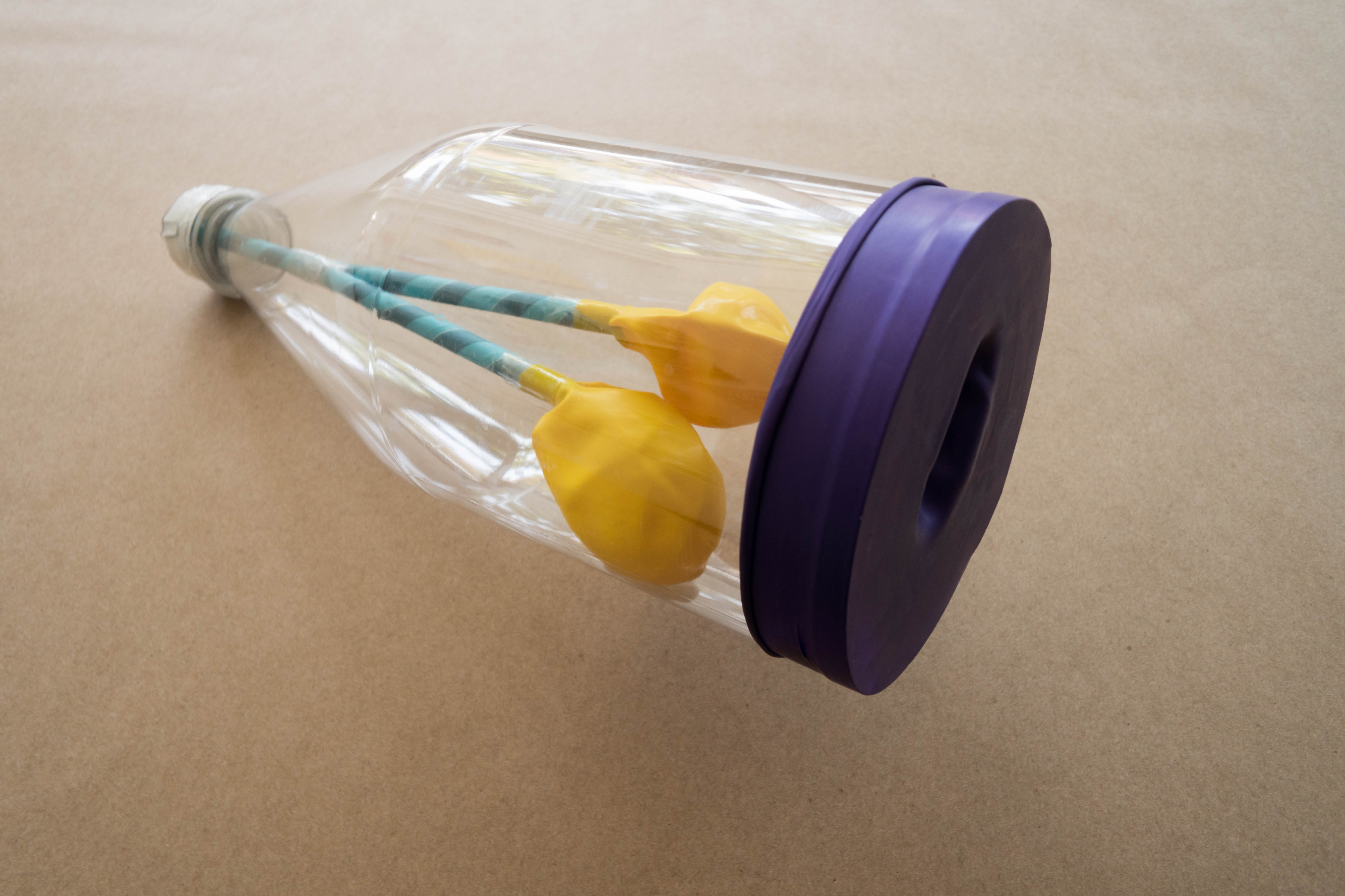 plastic bottle with straws and yellow balloons
