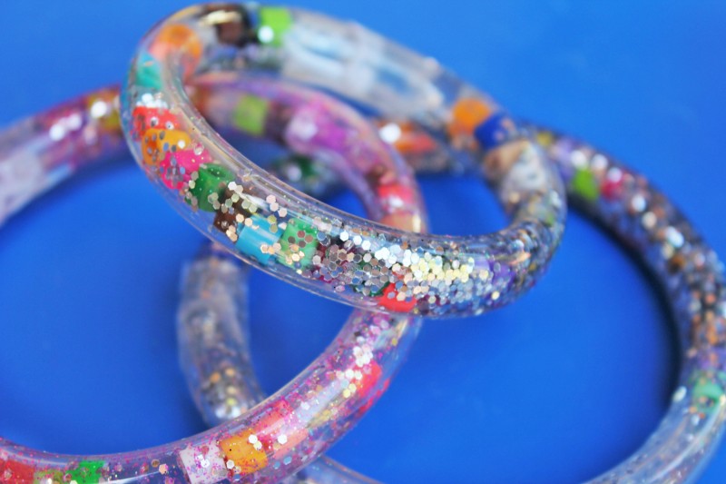bracelets made of a plastic tube with glitter on a blue background