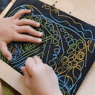 scratch art paper with small hands drawing