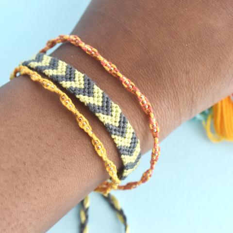 human wrist with three colorful woven bracelets