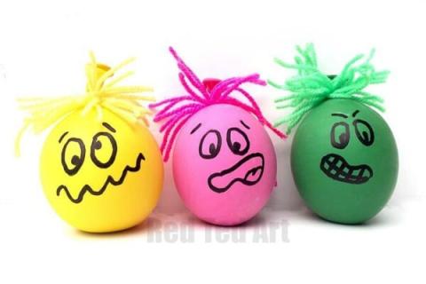 three small colorful balls with hand drawn faces