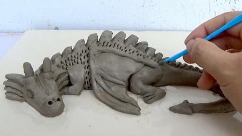 molding a clay dragon
