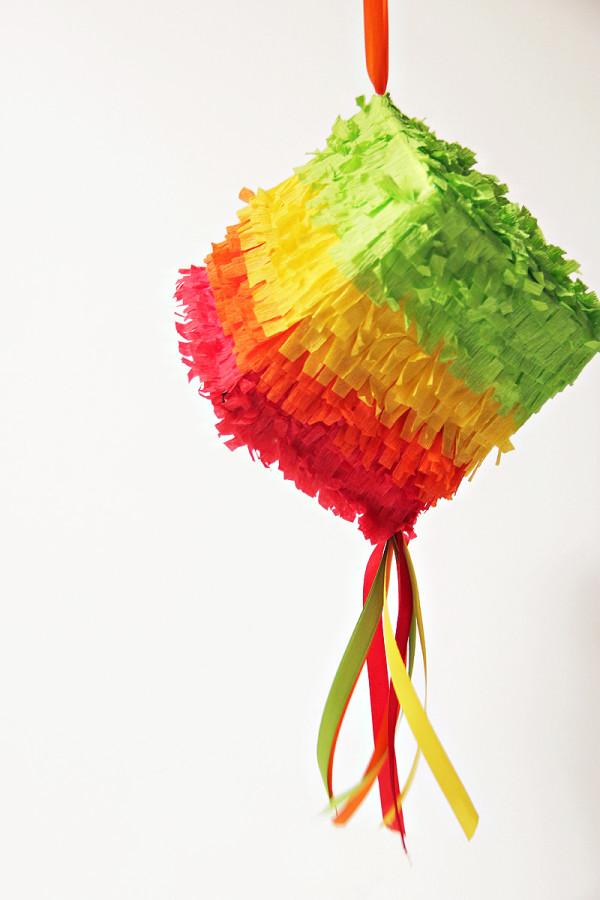 small square, multi-colored piñata with streamers