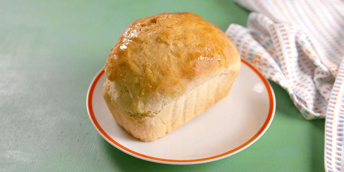 small loaf of white bread on a plate on a green table