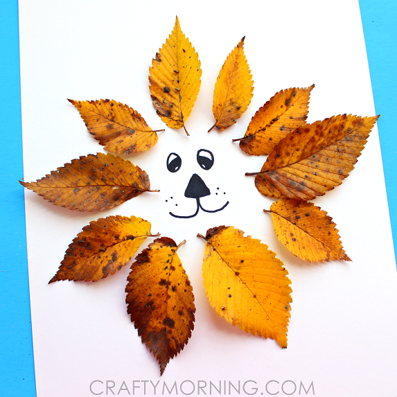 white paper with a lion face surrounded by yellow fall leaves